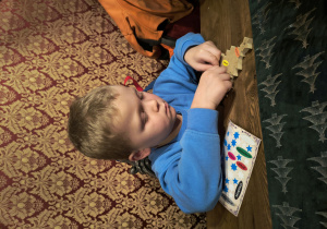 Dziecko ozdabia przywieszkę.