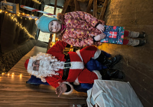 Dziecko odbiera od Mikołaja prezent.