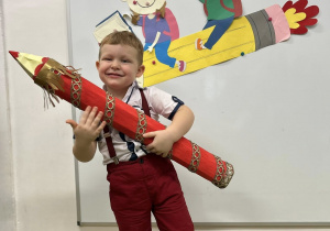 Chłopiec trzyma kredkę podczas pasowania.