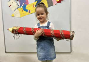 Dziewczynka trzyma kredkę podczas pasowania.