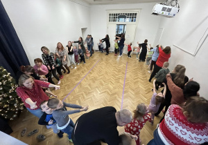 Dzieci wraz z rodzicami stoją w wielkim kole.