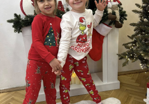 Dziewczyny z grupy IV stoją na tle dekoracji świątecznej.