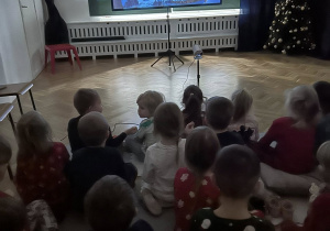 Dzieci z całego przedszkola oglądają wspólnie świąteczną bajkę.