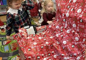 Dzieci otwierają wspólny prezent od Mikołaja.