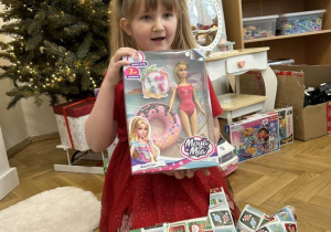 Dziecko otwiera wspólny prezent od Mikołaja.