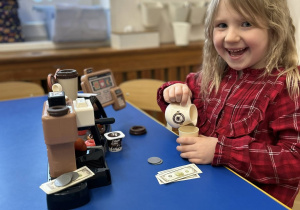 Dziewczynka bawi się nową zabawką, otrzymaną od Mikołaja.