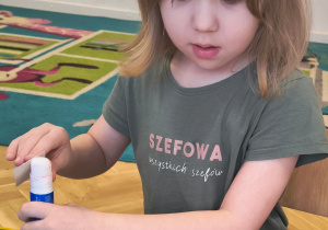Dziewczynka przykleja figury geometryczne.