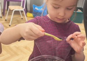 Dziewczynka sypie herbatkę do torebek.