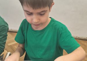 Chłopiec sypie herbatkę do torebek.