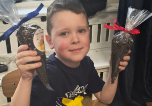 Chłopiec pokazuje swoją herbatkę.