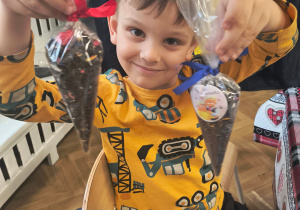 Chłopiec pokazuje swoją herbatkę.