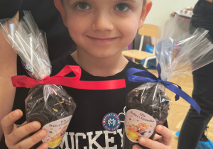 Chłopiec pokazuje swoją herbatkę.