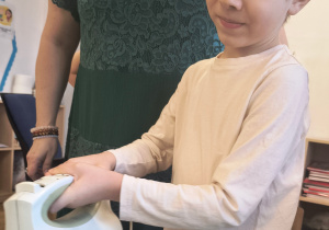 Chłopiec miesza mikserem masę budyniową.