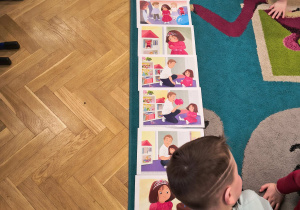 Chłopiec układa historyjkę obrazkową z plansz dydaktycznych.