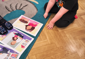 Chłopiec układa historyjkę obrazkową z plansz dydaktycznych.