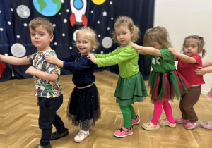 Dzieci z grupy pierwszej trzymają się za ramiona, tworząc pociąg.