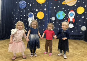 Cztery dziewczynki z grupy pierwszej trzymają się za ręce.