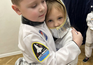 Chłopiec i dziewczynka z grupy III przytulają się do siebie.