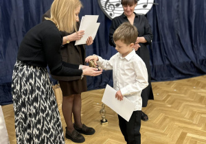 Chłopiec odbiera nagrodę od jury.