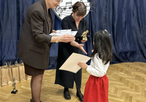 Dziewczynka odbiera nagrodę od jury.