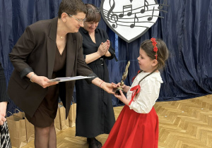 Dziewczynka odbiera nagrodę od jury.