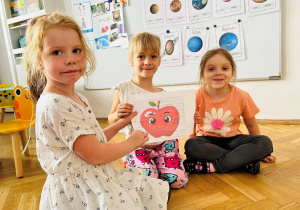 Dzieci pokazują obrazek z puzzli - jabłko.