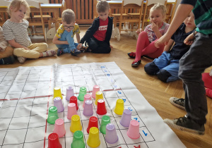Dzieci układają z kubków sudoku.