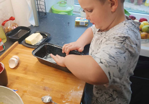 Chłopiec w kuchni, przygotowuje chlebek.
