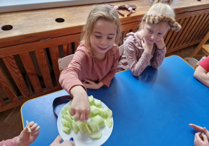 Dzieci jedzą ogórki.