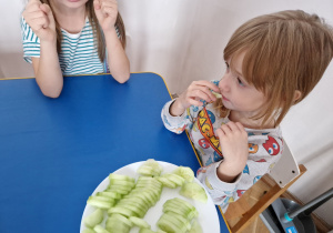 Dzieci jedzą ogórki.